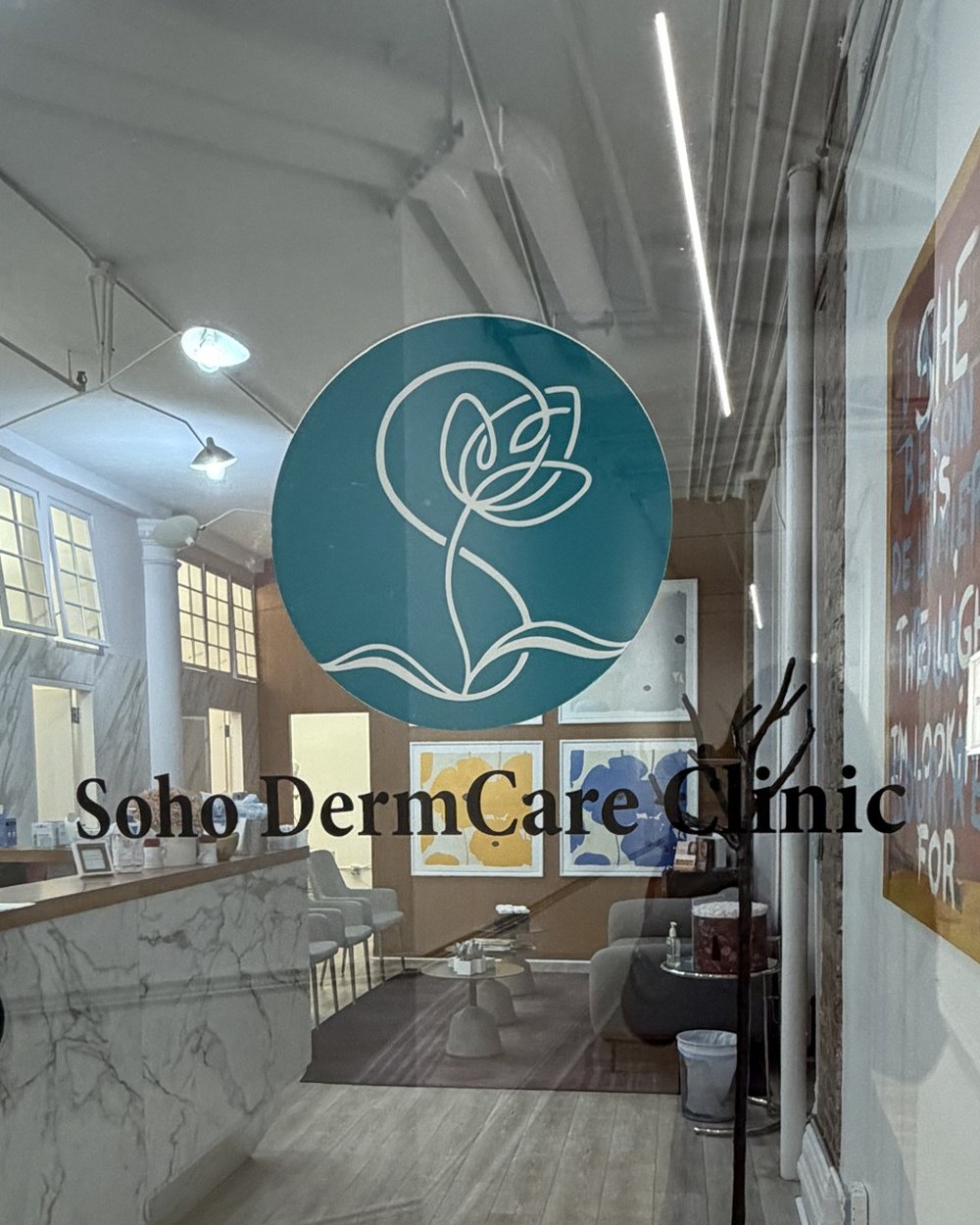 Glass entrance door at 594 Broadway Suite 409 with the Soho DermCare Clinic mark and lettering on the glass